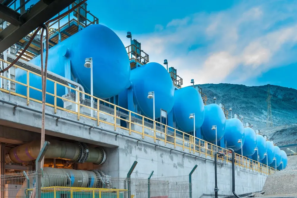 Large blue industrial tanks in mining facility